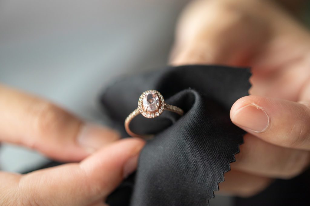 Photo of jeweler cleaning ring with fabric cloth.