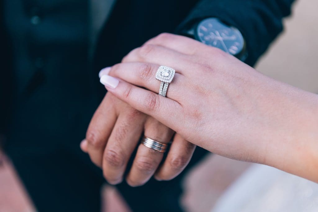 Photo showcasing husband and wife wearing wedding rings