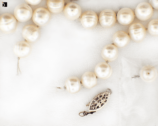 Image showcasing a string of pearls necklace before it gets a necklace repair