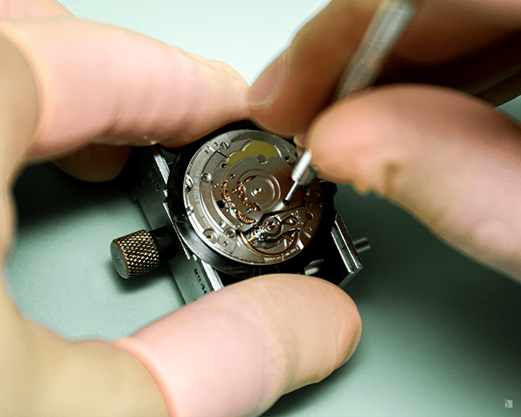 Close Up of Expert Watchmaker Unscrewing Watch Movement For Timepiece Servicing