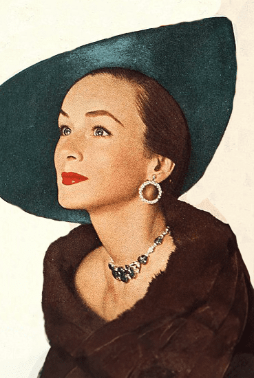 Colored photo showing woman in Revlon magazine wearing green rhinestone necklace and diamond rhinestone drop hoop earrings circa 1950s