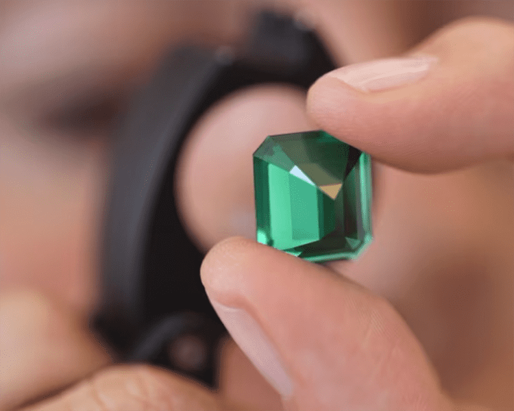 Jeweler Inspecting Cut Emerald Gemstone from Muzo Mines Feature Image Financial Times