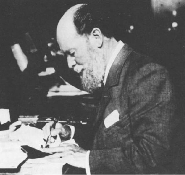 Photo of Peter Carl Fabergé working at his desk black and white