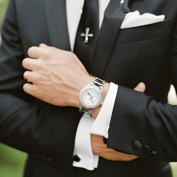 Photo of Russian groom wearing wristwatch and cross tie pin.