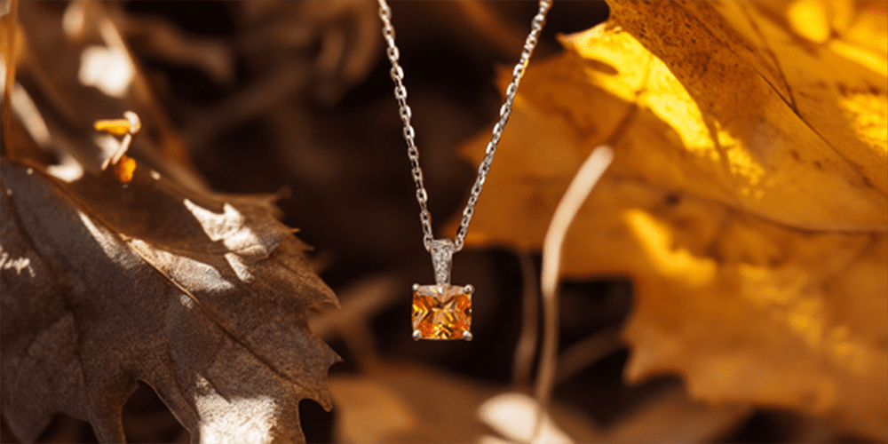 Restored Orange Gemstone Pendant Necklace Hanging in Front of Fall Leaves in Autumn Seasonal Display