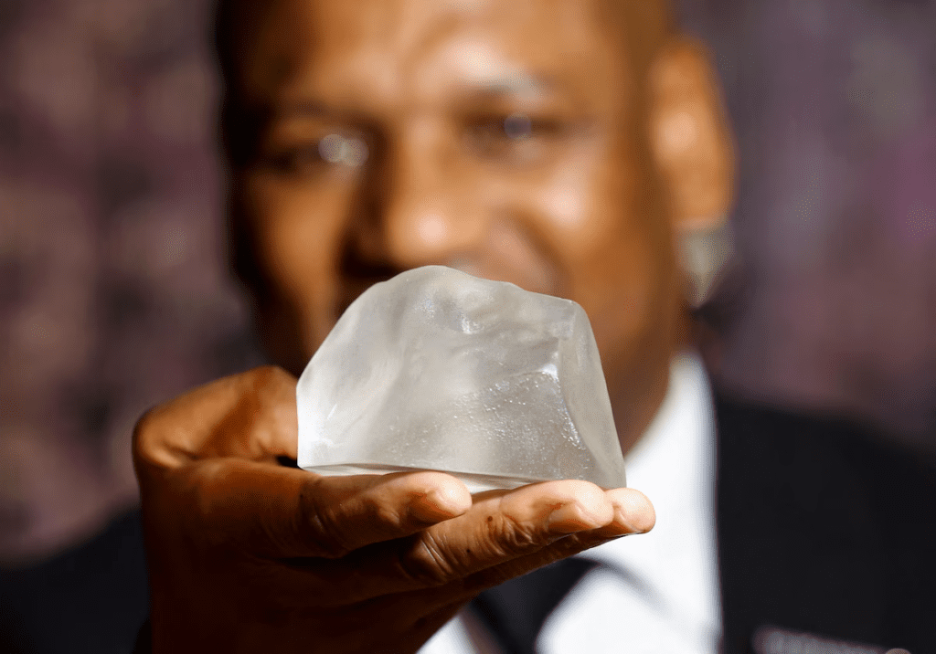 Photo of staff member Pule Musi holding replica of the Cullinan Diamond via The Washington Post