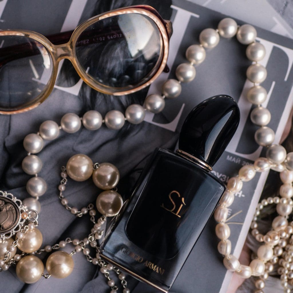 Image of giorgio armani jewelry with sunglasses and perfume on Elle magazine
