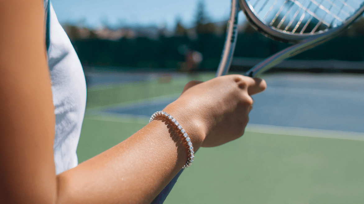 Image showcasing female tennis player holding tennis racket and wearing tennis bracelet