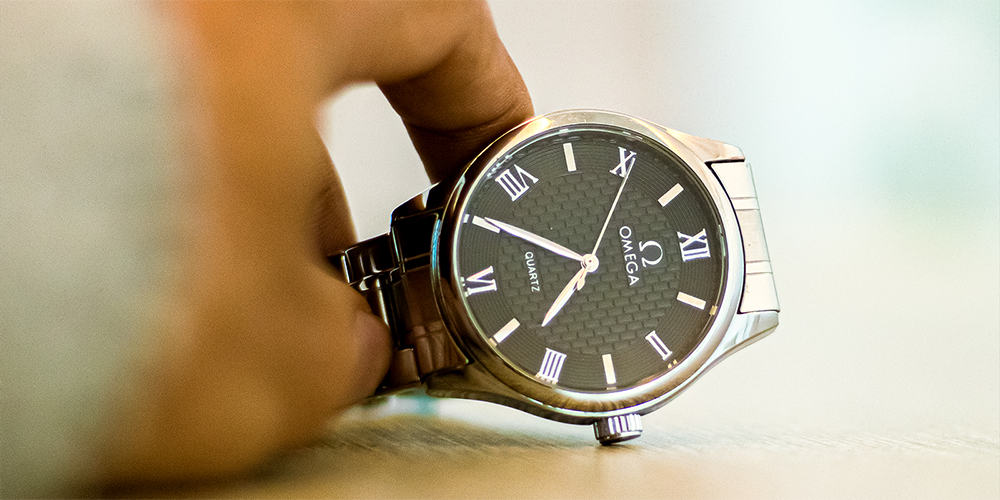 Hand Holding Serviced Omega Quartz Watch with Black Dial